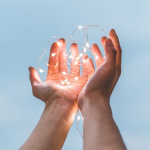 Upclose image of 2 hands holding fairy lights